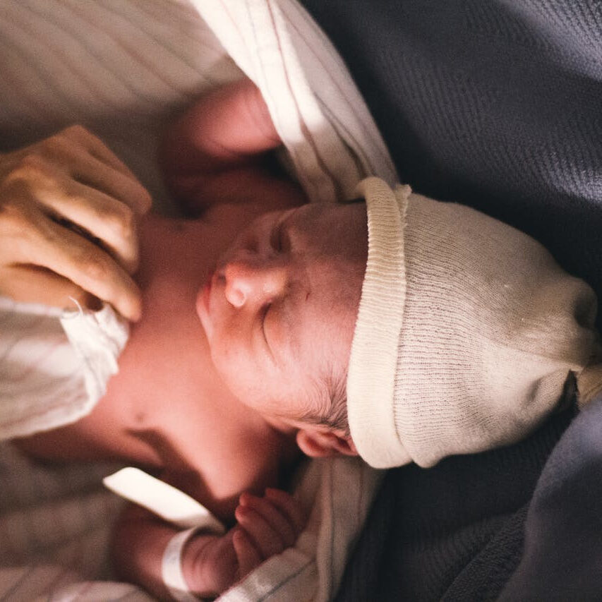 Newborn baby held at a Brit ceremony