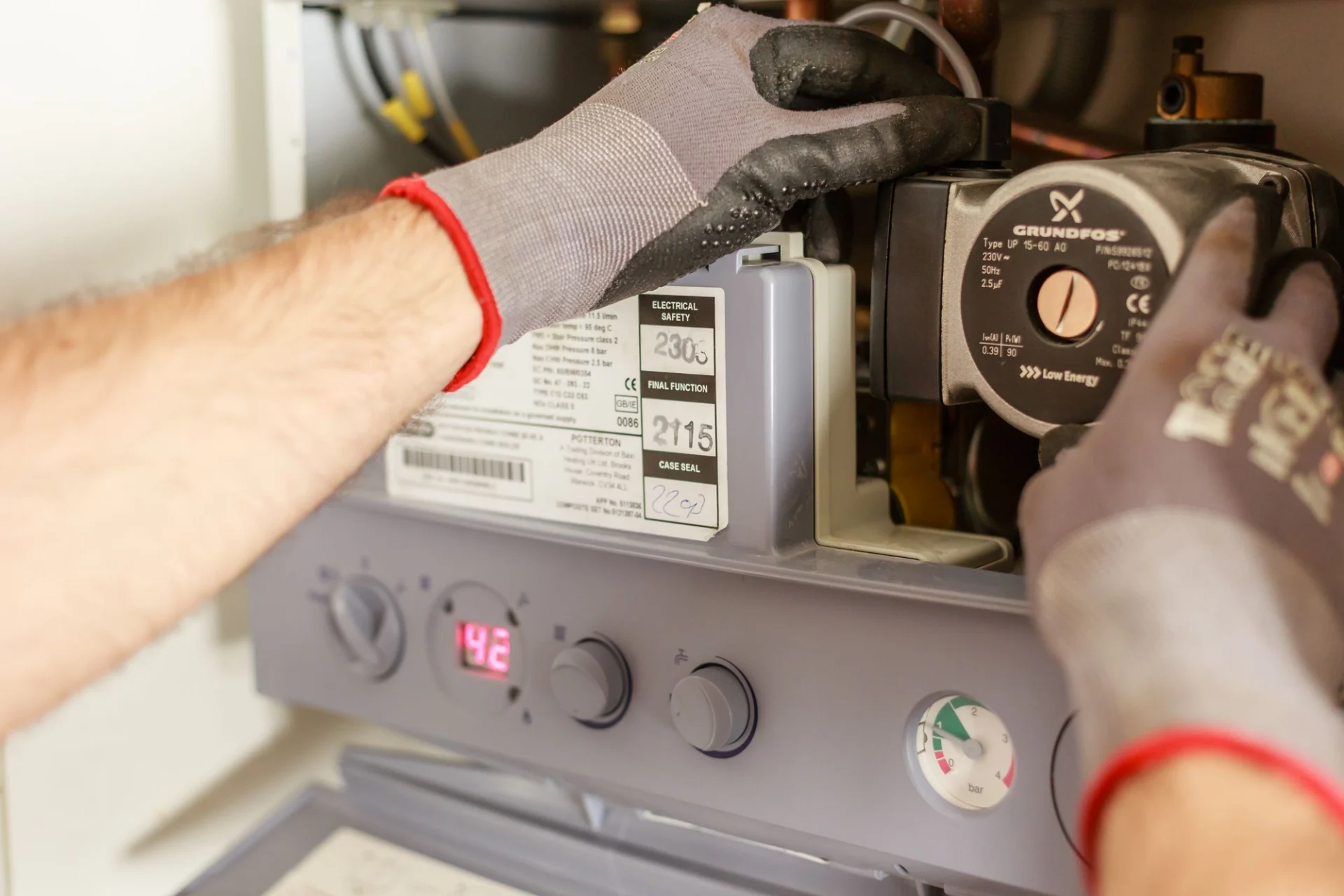 Hands repairing a domestic boiler