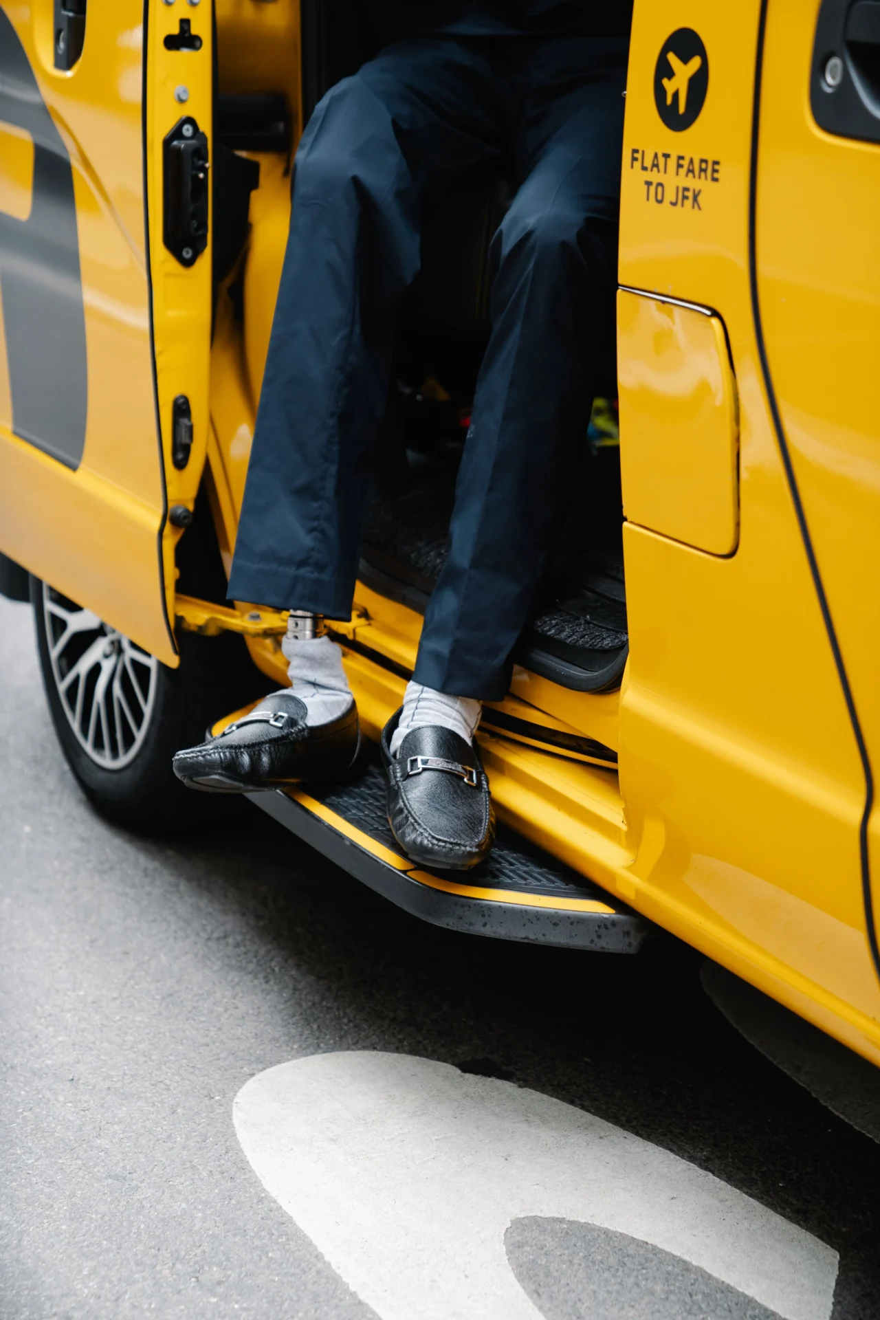 Stepping out of a taxi at the kerb