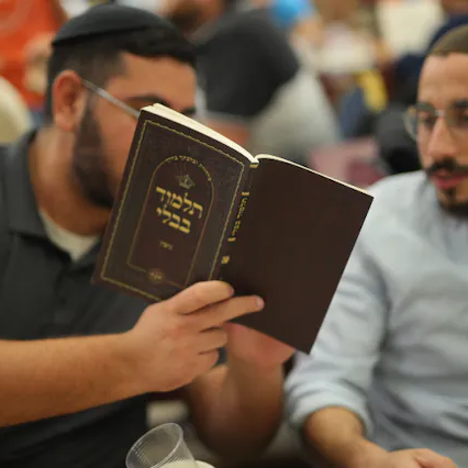 Adult studying from a bound volume
